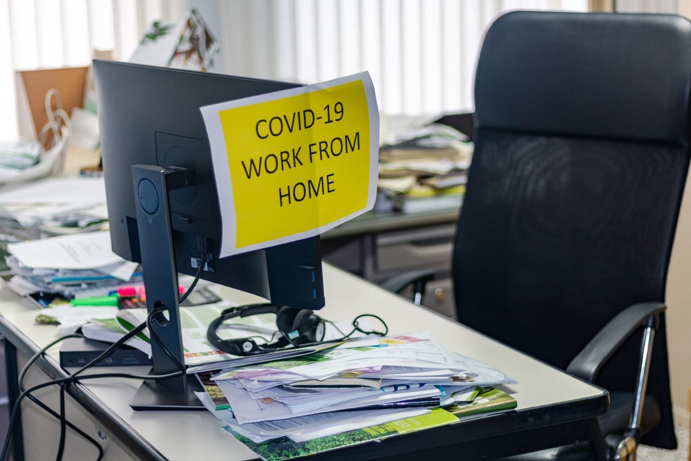 Abandoned office desk with a work from home sign.